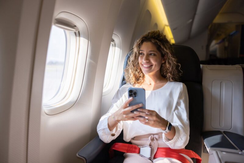 A female passenger sitting in a window seat on a plane