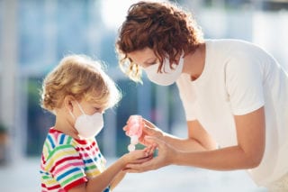 Mother with child using hand sanitizer to stay healthy while abroad.