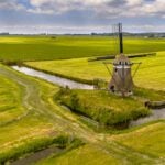 Old wooden windmill in green agricultural grassland in the Netherlands