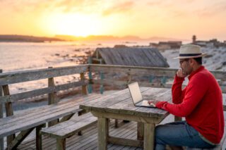 digital nomad working abroad sitting outdoors at the beach