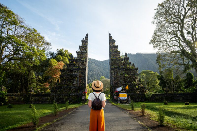 a woman standing in front of a Bali temple having moved to the country after researching the cost of living in Indonesia