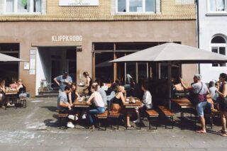 expats in Germany sitting on a bench having a beer outside a pub in Hamburg