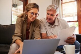 a couple sitting at a laptop research how to file their U.S. tax returns