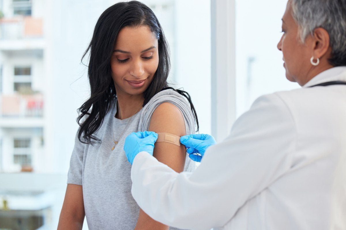 a woman getting a vaccination before traveling abroad, having read our international healthcare tips