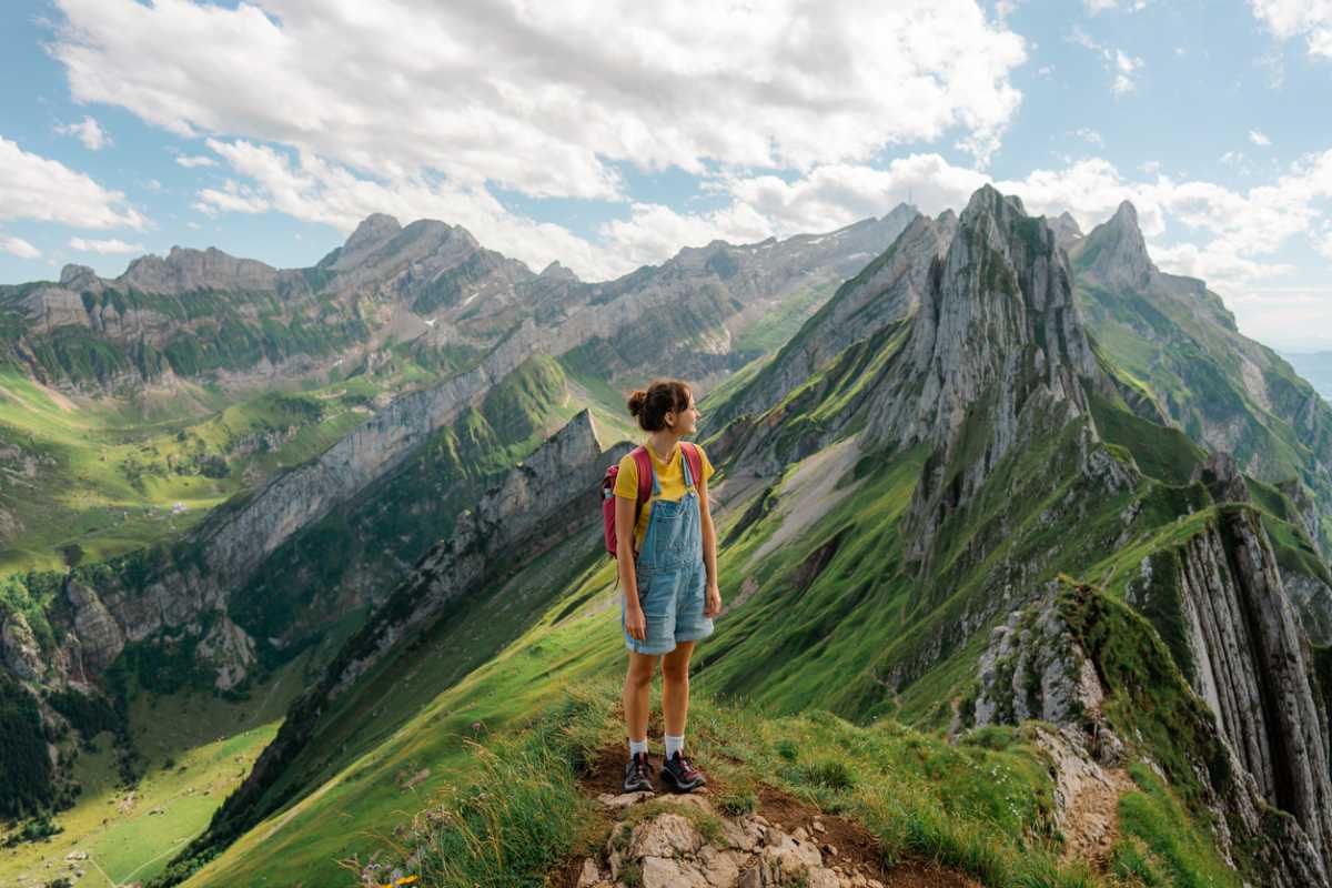 A woman hiking through the Swiss Alps, showcasing Switzerland as one of the best countries for solo travel for women