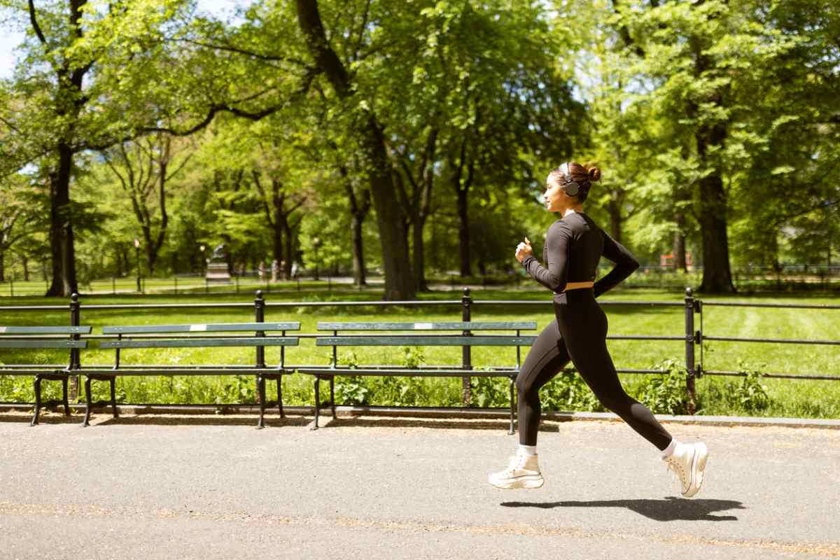 a woman jogging in a park on a sunny day, having read our international healthcare tips for expats