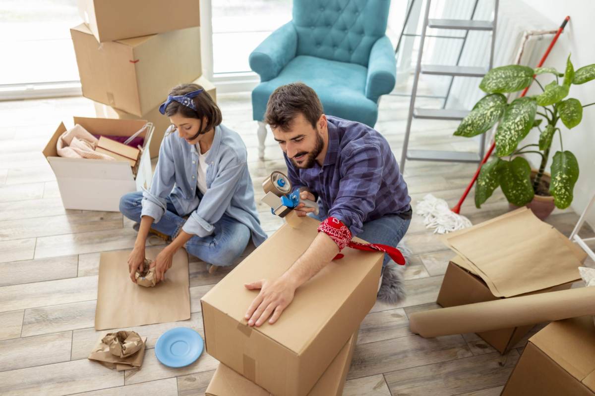 a couple packing their belongings into boxes as they prepare for moving abroad