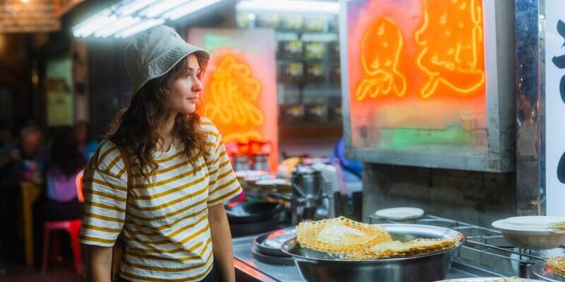 a caucasean woman feeling a sense of culture shock as she explores Chinatown night market in Bangkok