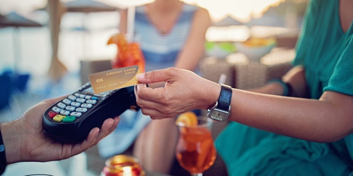 a man paying for cocktails at a beach bar using a contactless credit card