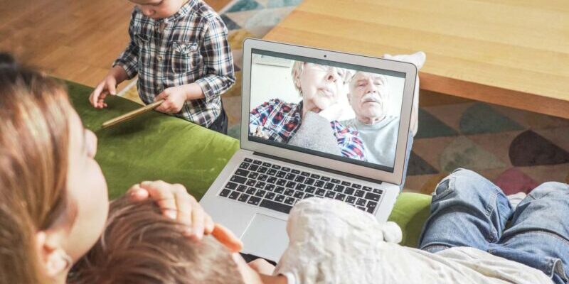 a Young mom and sons having a facetime video call with grandparents to help overcome feelings of culture shock in their new home