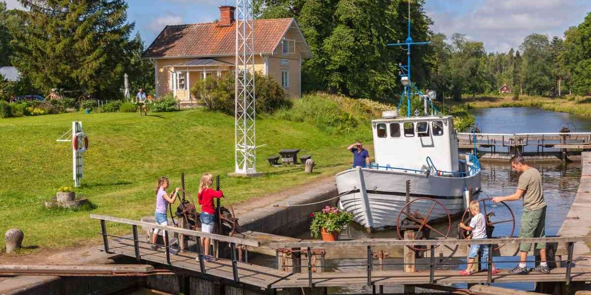 a dad with his children opening a lock gate in a canal in Sweden