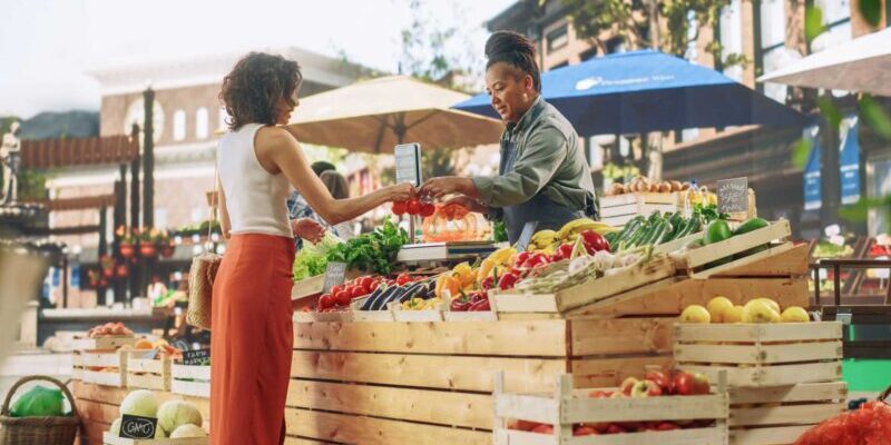 a female expat shopping for fresh vegetables at a local farmers market