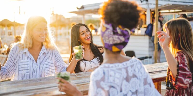 a group of young female friends laughing and socialising, enjoying one of the many perks of living abroad