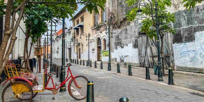 a red bike parked on an empty street in Kota Lama, Semarang