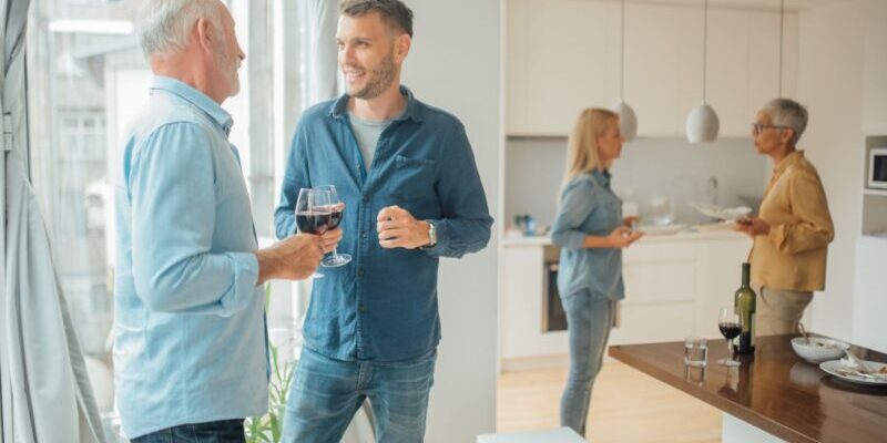 a father and son having a conversation over a glass of red wine