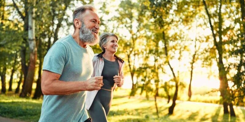 a happy couple jogging after retiring abroad to a warm climate