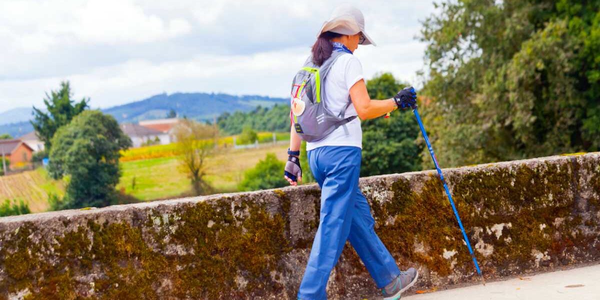 a female backpacker hiking the 'Camino de Santiago' in Galicia, Spain, one of the top destinations when it comes to solo travel for women